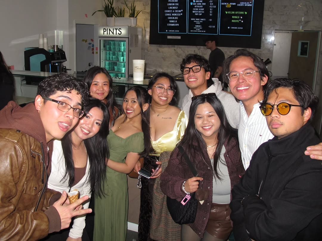 A big group portrait inside Parlour Ice Cream, everyone smiling under the shop lights